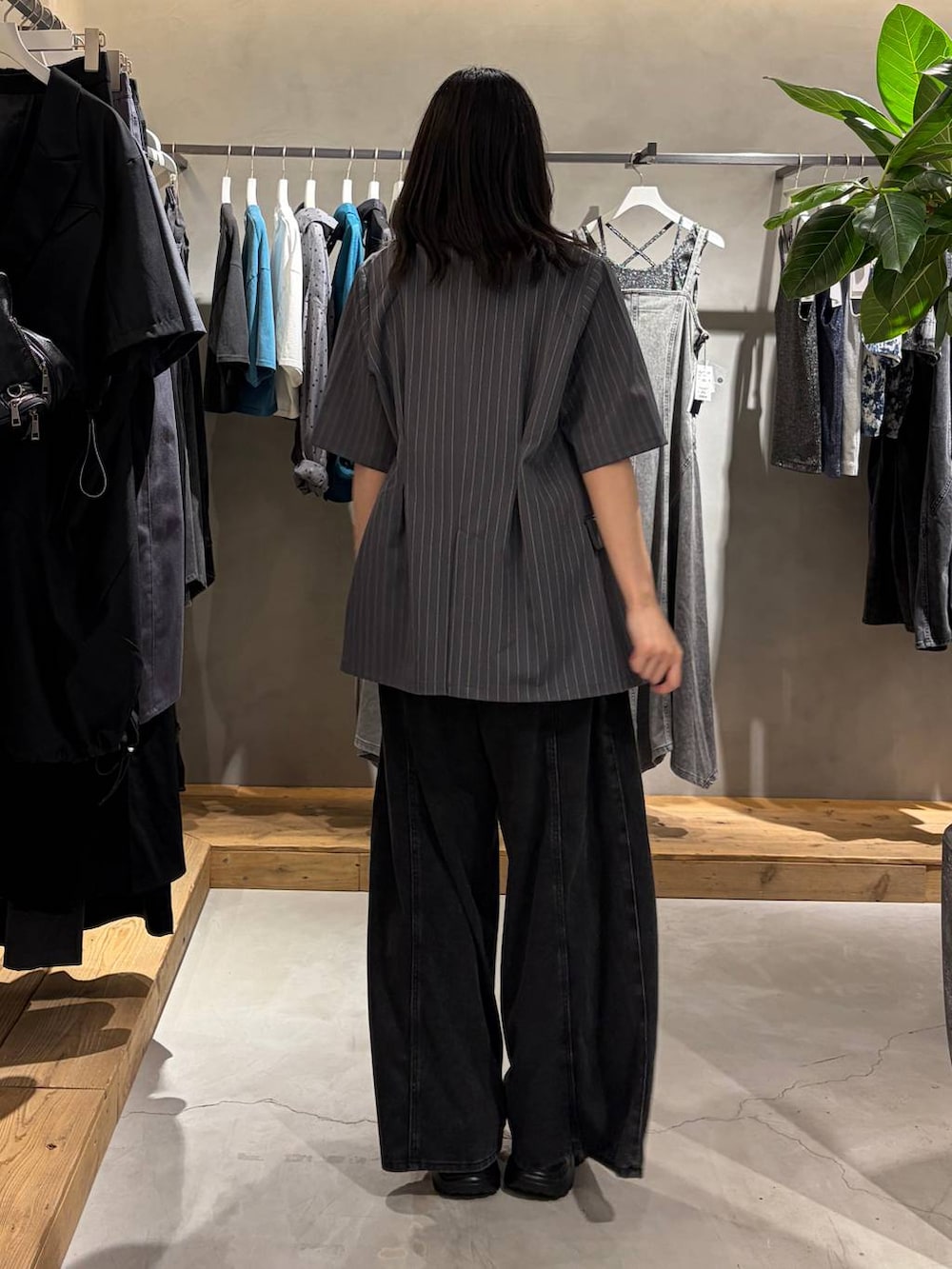 ブラック系のデニムパンツ、ブラック系のTシャツ/カットソー、ブラック系のサンダルを着用したレディースの夏コーディネートの3枚目の写真