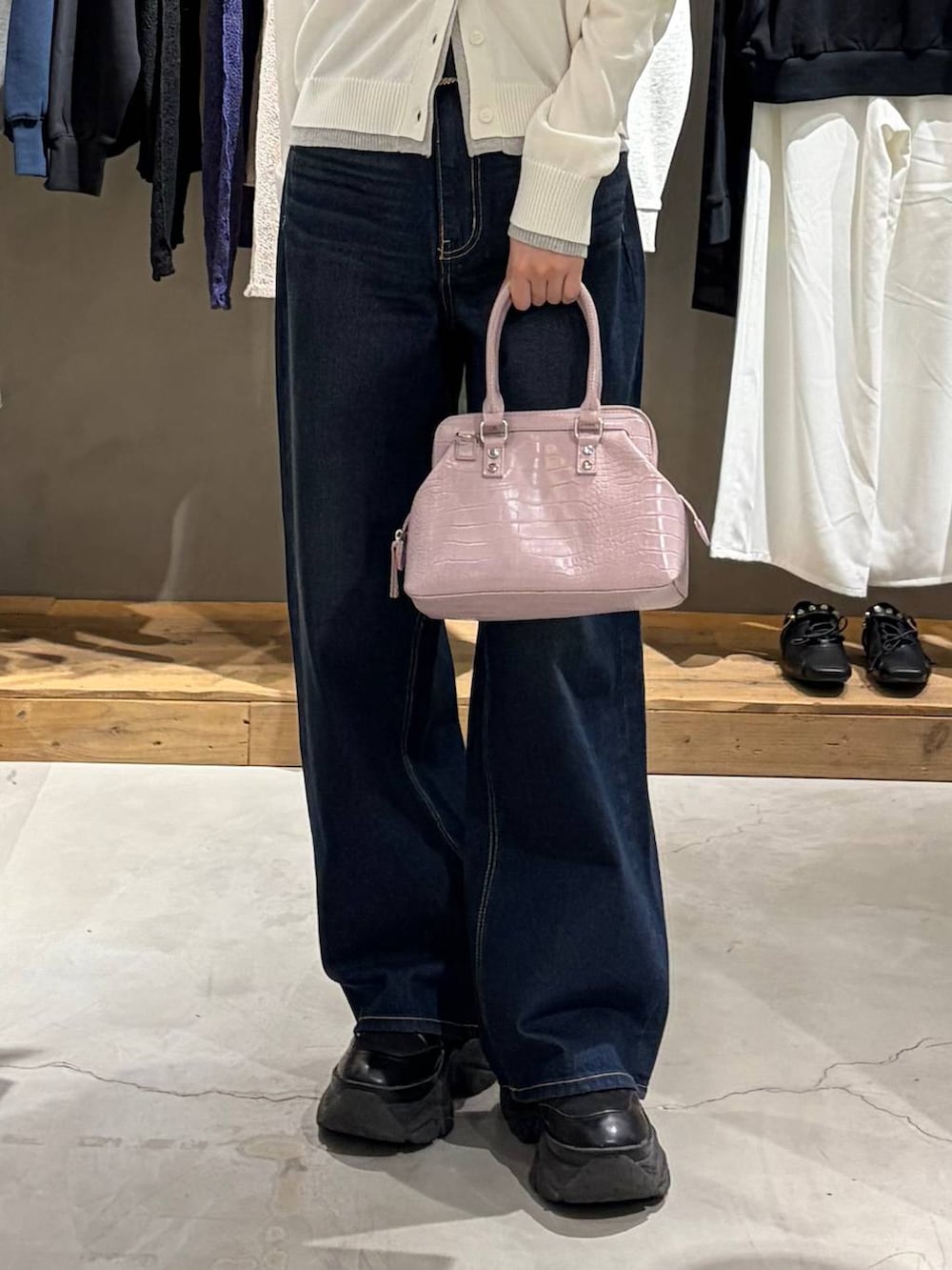 ブラック系のブーツ、ブルー系のスラックス、ピンク系のハンドバッグを着用したレディースの冬コーディネートの5枚目の写真