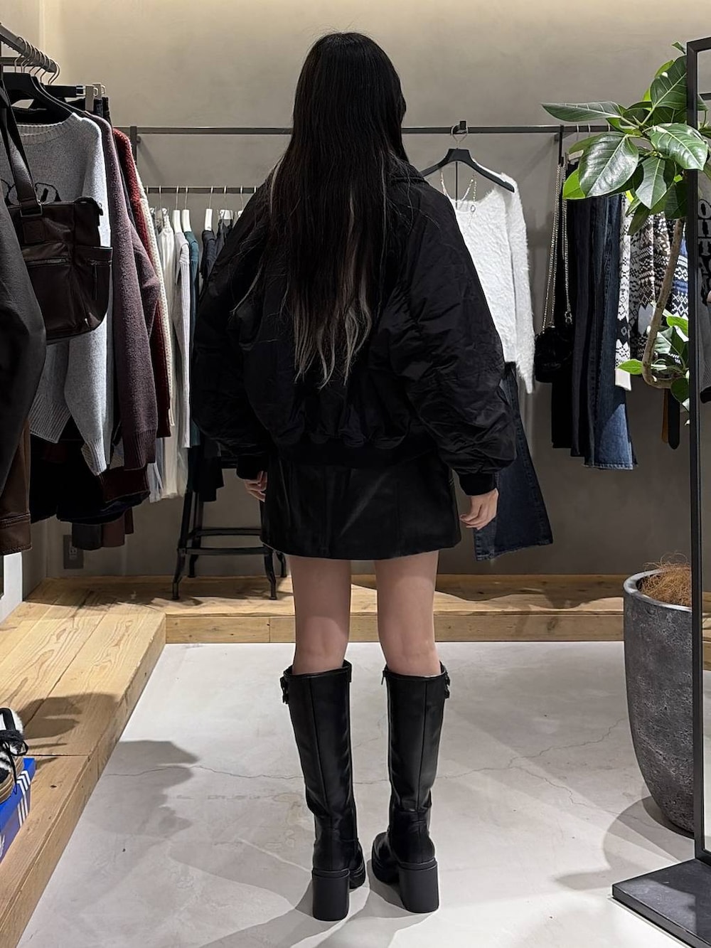 ブラック系のブーツ、ブラック系のスカート、ブラック系のブルゾンを着用したレディースの冬コーディネートの3枚目の写真