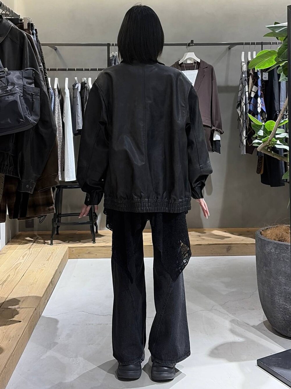 ブラック系のブーツ、ブラック系のデニムパンツ、ブラック系のブルゾンを着用したレディースの秋コーディネートの3枚目の写真