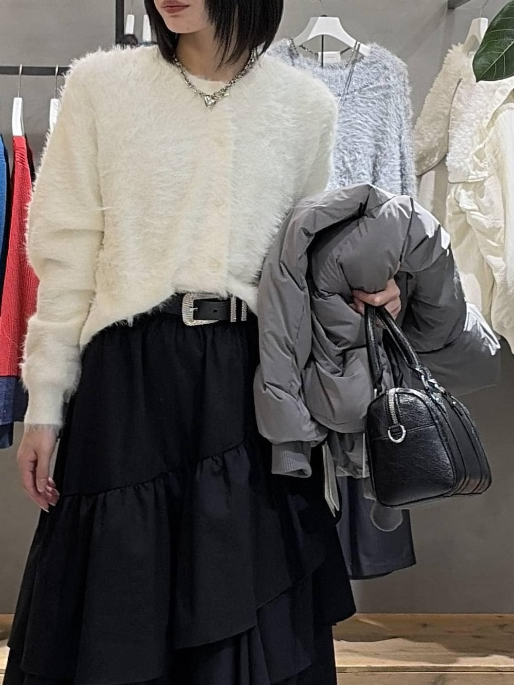 グレー系のブルゾン、ブラック系のスカート、ブラック系のボストンバッグを着用したレディースの冬コーディネートの4枚目の写真