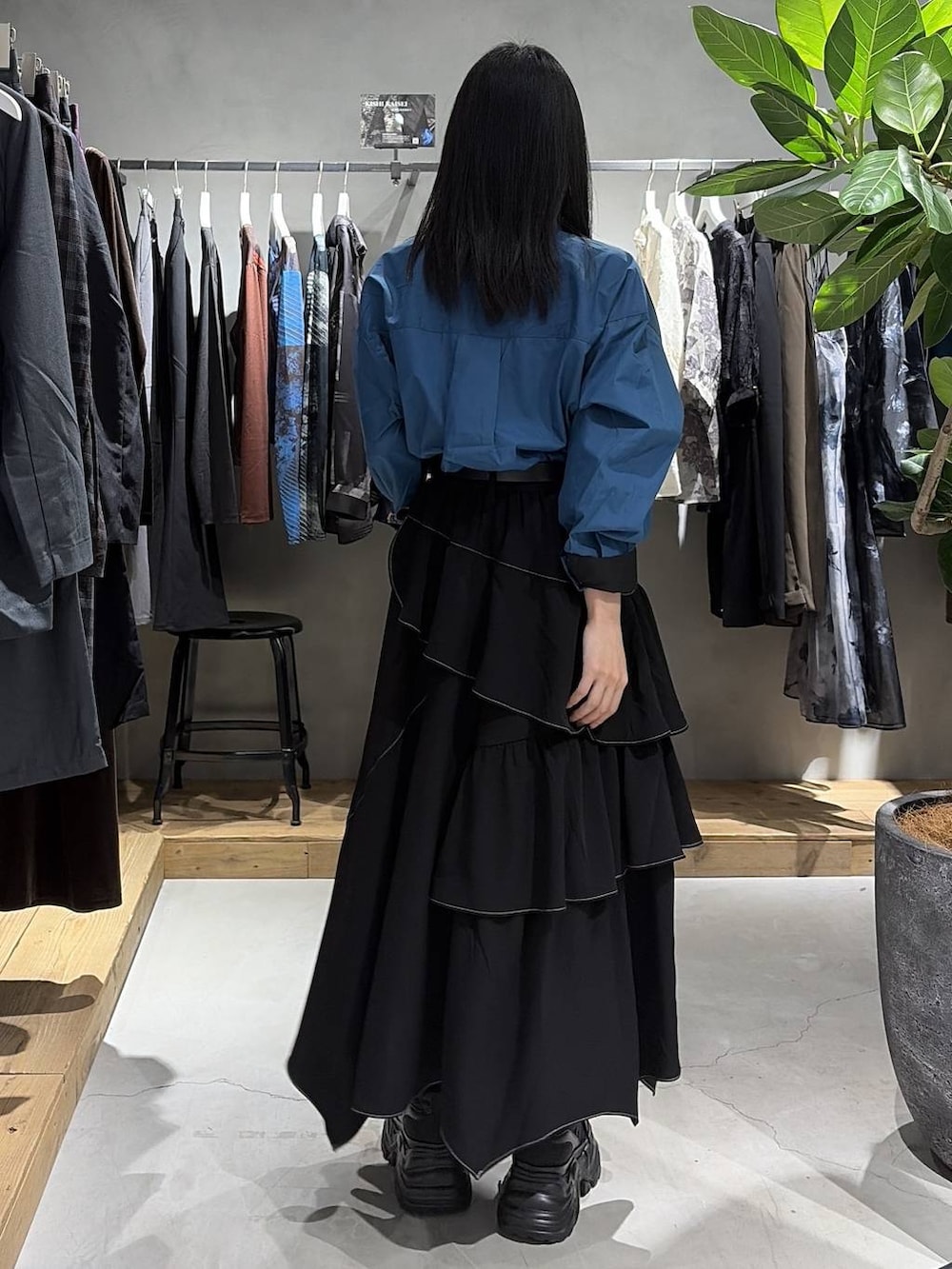 ブラック系のスカート、ブルー系のシャツ/ブラウス、ブラック系のスニーカーを着用したレディースの夏コーディネートの3枚目の写真