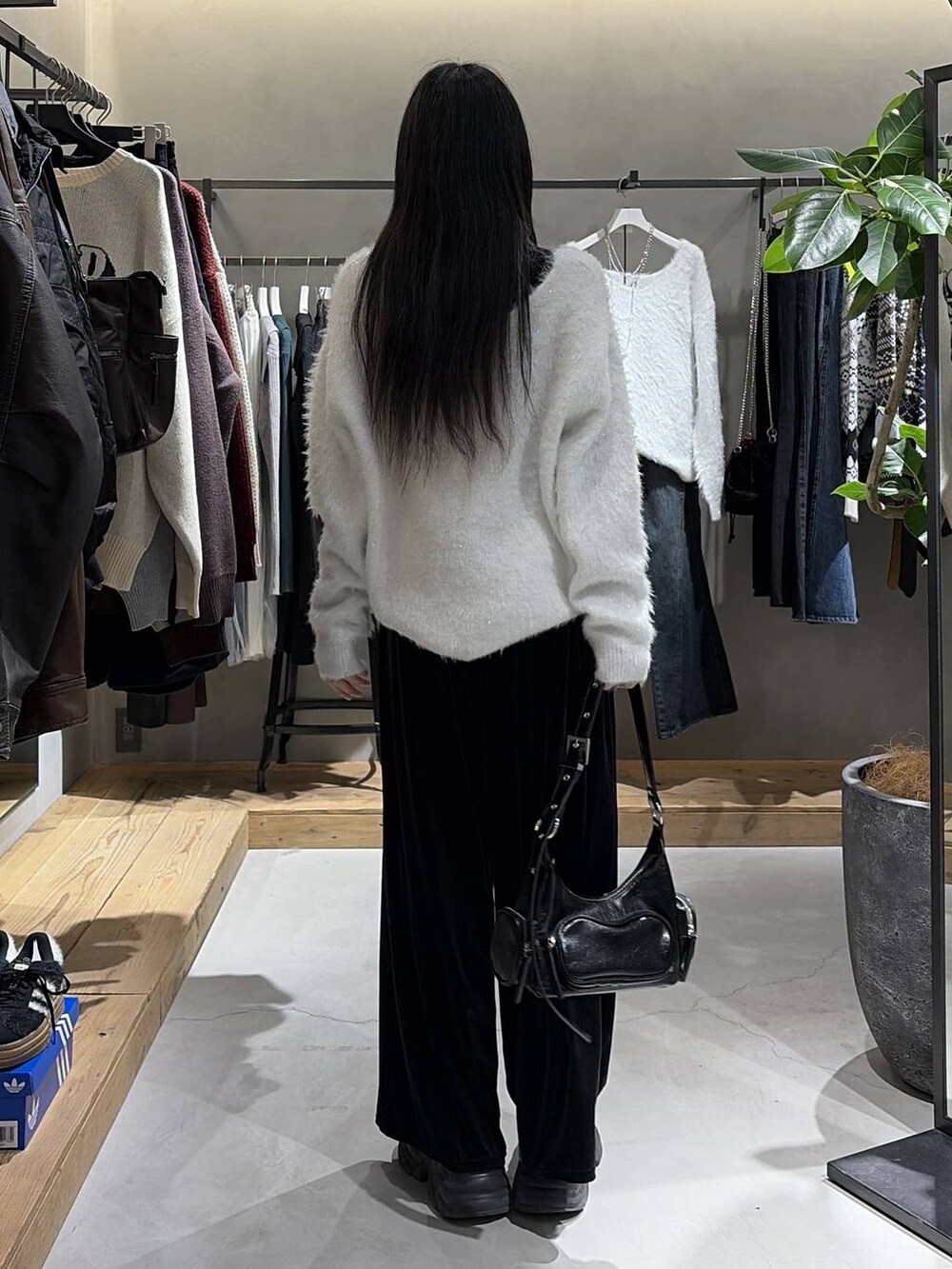 ブラック系のブーツ、ブラック系のショルダーバッグ、ホワイト系のニット/セーターを着用したレディースの冬コーディネートの3枚目の写真