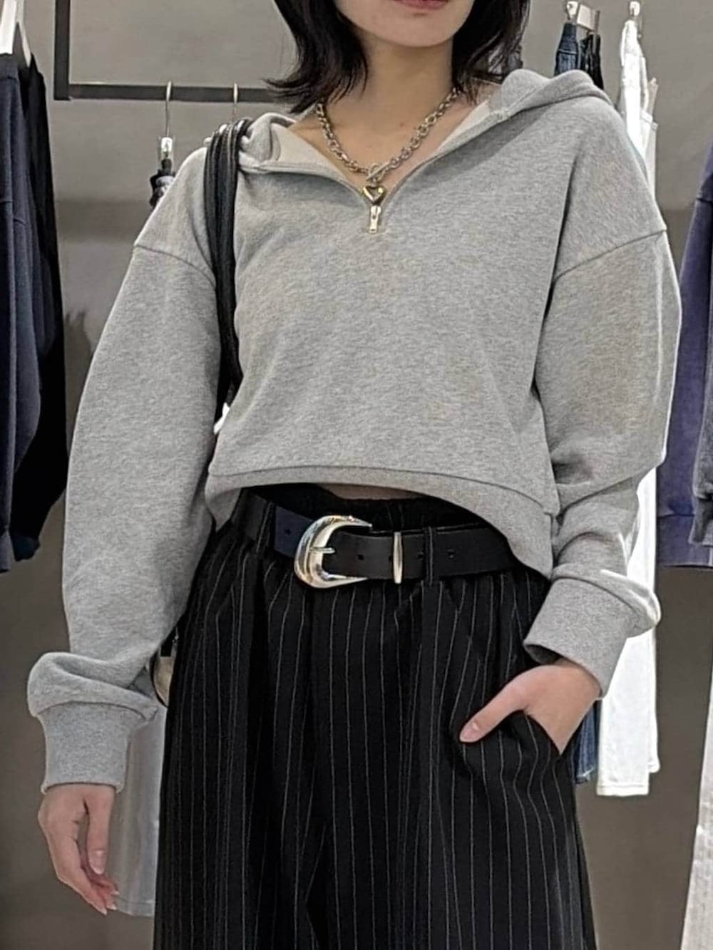 ブラック系のブーツ、ブラック系のボストンバッグ、グレー系のパーカーを着用したレディースの冬コーディネートの4枚目の写真