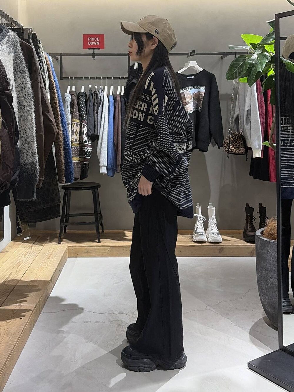 ブラック系のブーツ、ブラック系のデニムパンツ、ブルー系のニット/セーターを着用したレディースの冬コーディネートの2枚目の写真