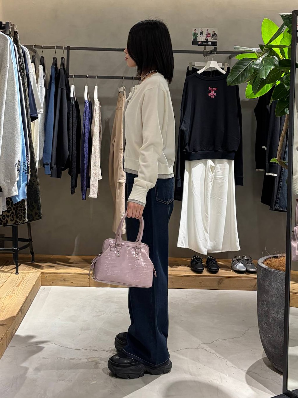 ブラック系のブーツ、ブルー系のスラックス、ピンク系のハンドバッグを着用したレディースの冬コーディネートの2枚目の写真