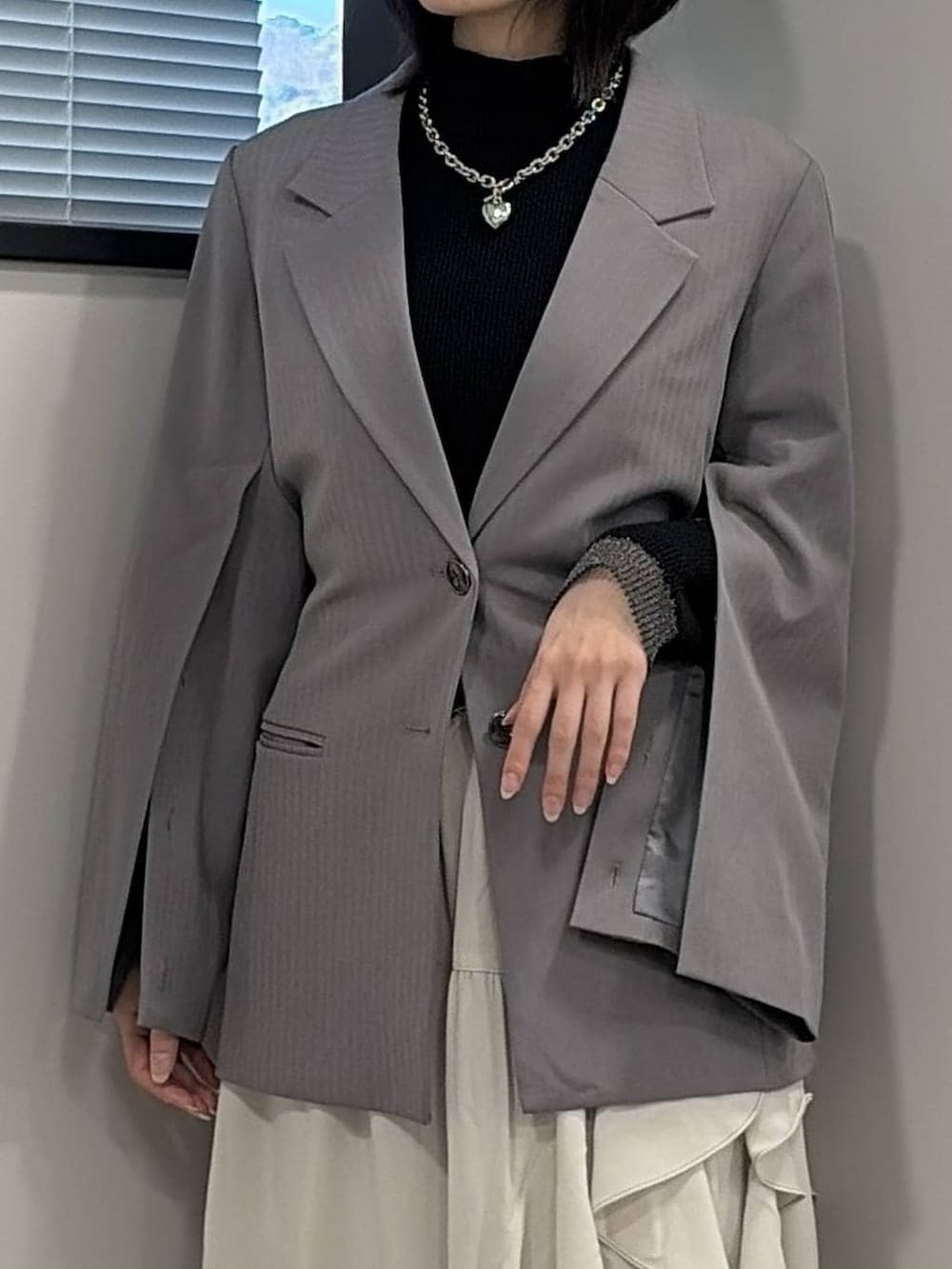 ブラック系のブーツ、ブラック系のニット/セーター、グレー系のテーラードジャケットを着用したレディースの冬コーディネートの4枚目の写真