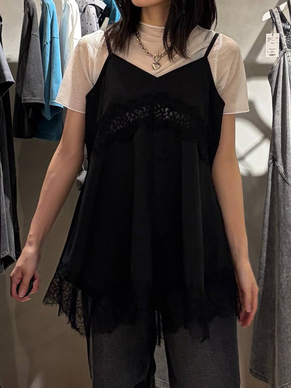 ブラック系のキャミソール、ブラック系のデニムパンツ、ブラック系のサンダルを着用したレディースの夏コーディネートの4枚目の写真