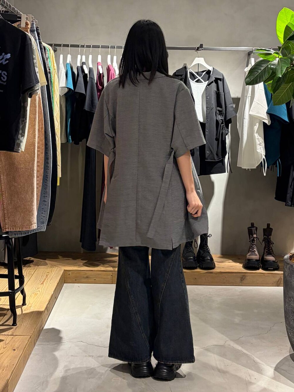 ブルー系のデニムパンツ、ブラック系のサンダル、ブラック系のTシャツ/カットソーを着用したレディースの春コーディネートの3枚目の写真