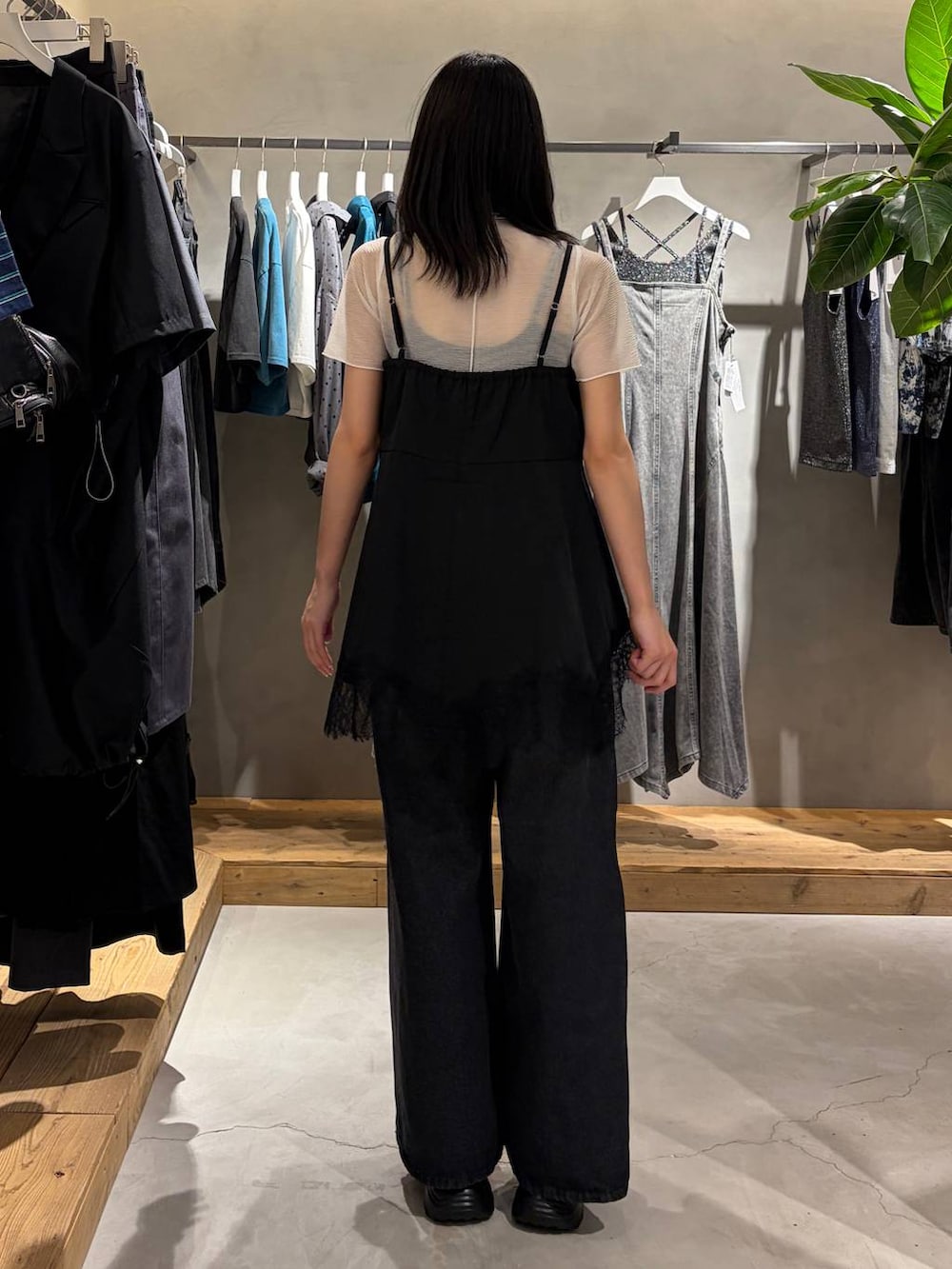 ブラック系のキャミソール、ブラック系のデニムパンツ、ブラック系のサンダルを着用したレディースの夏コーディネートの3枚目の写真