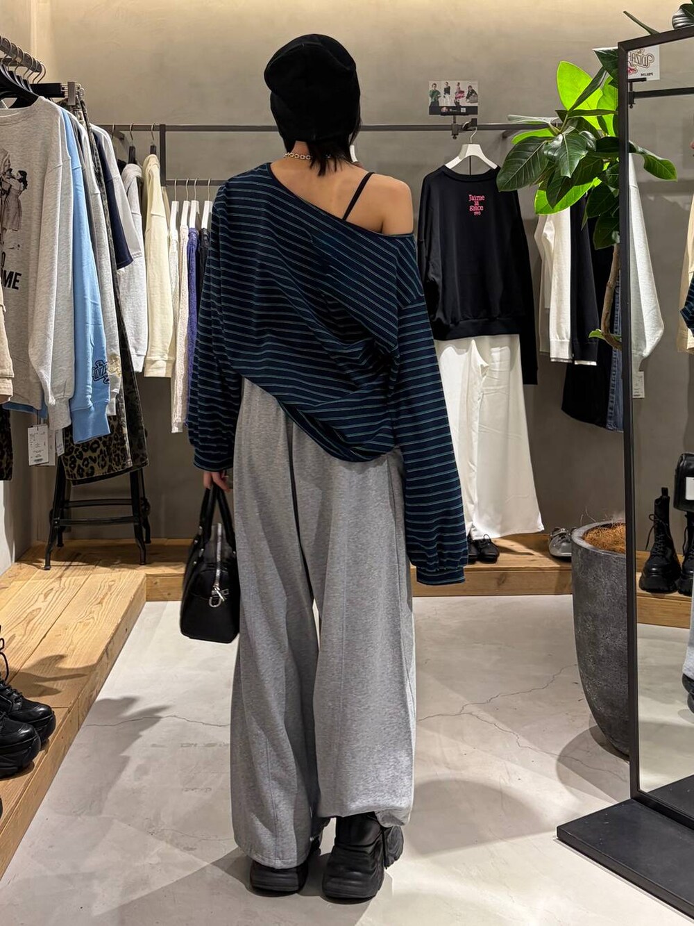 ブラック系のブーツ、ブラック系のボストンバッグ、グレー系のスウェットパンツを着用したレディースの冬コーディネートの3枚目の写真