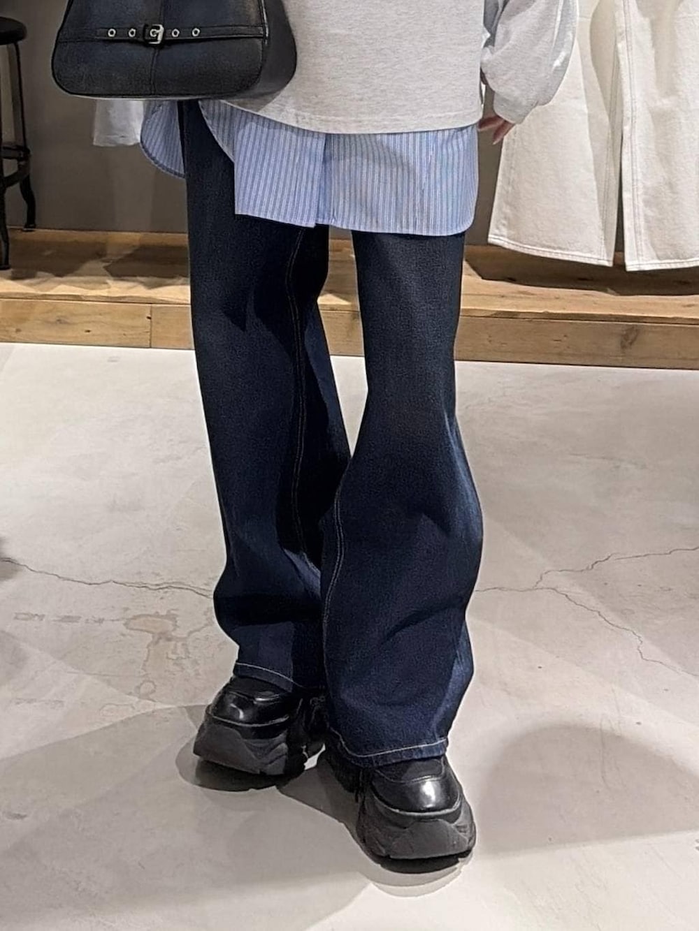 ブラック系のブーツ、ブルー系のスラックス、ブラック系のハンドバッグを着用したレディースの冬コーディネートの5枚目の写真