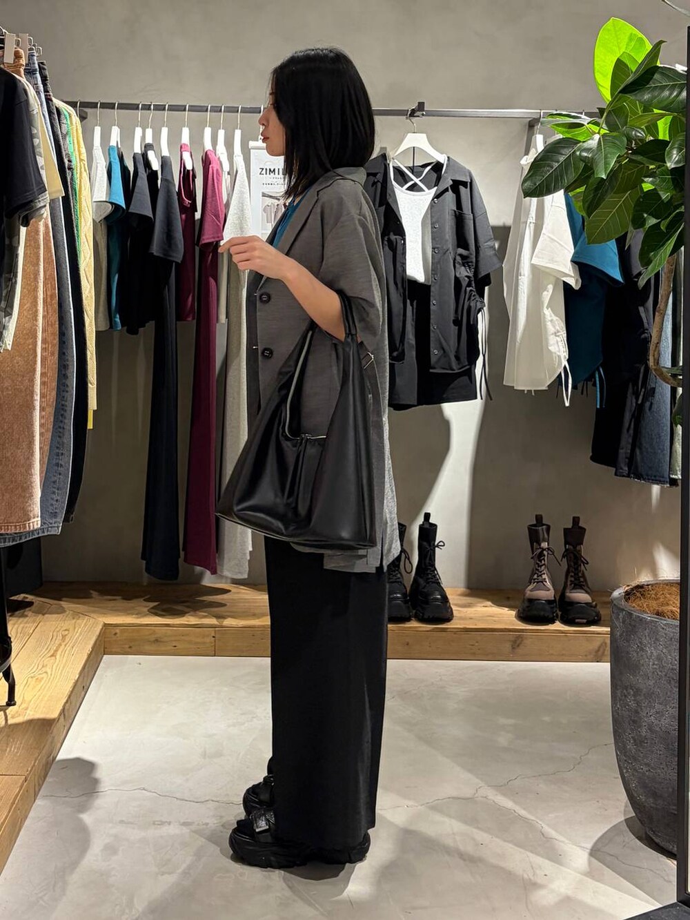 ブラック系のトートバッグ、ブラック系のサンダル、ブラック系のスラックスを着用したレディースの春コーディネートの2枚目の写真