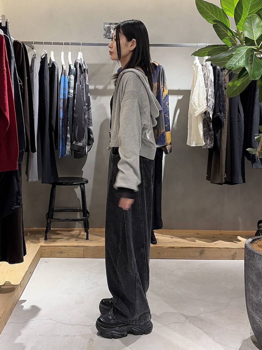 グレー系のパーカー、ブラック系のシャツ/ブラウス、ブラック系のデニムパンツを着用したレディースの秋コーディネートの2枚目の写真