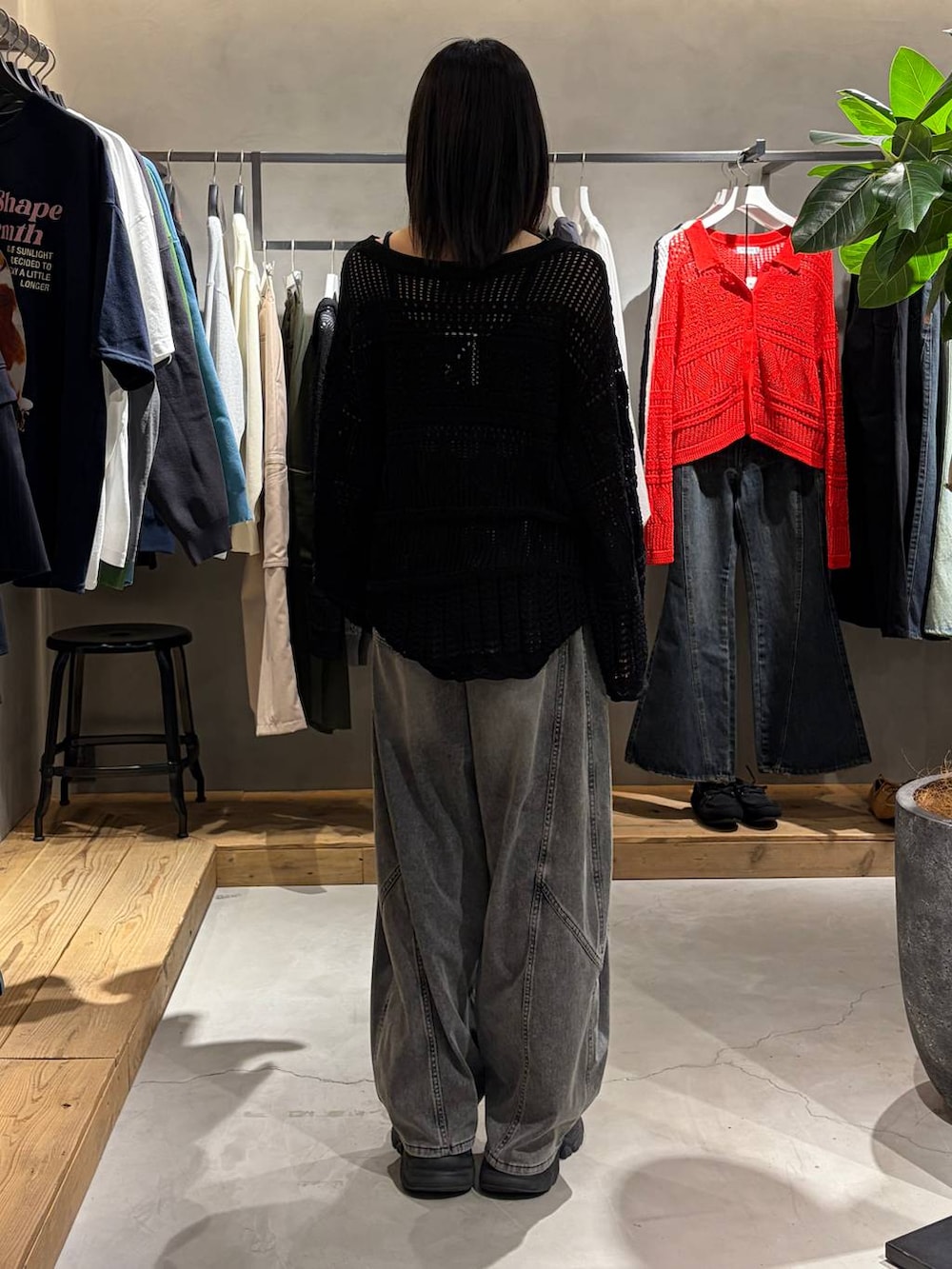 ブラック系のブーツ、ブラック系のデニムパンツ、ブラック系のニット/セーターを着用したレディースの春コーディネートの3枚目の写真