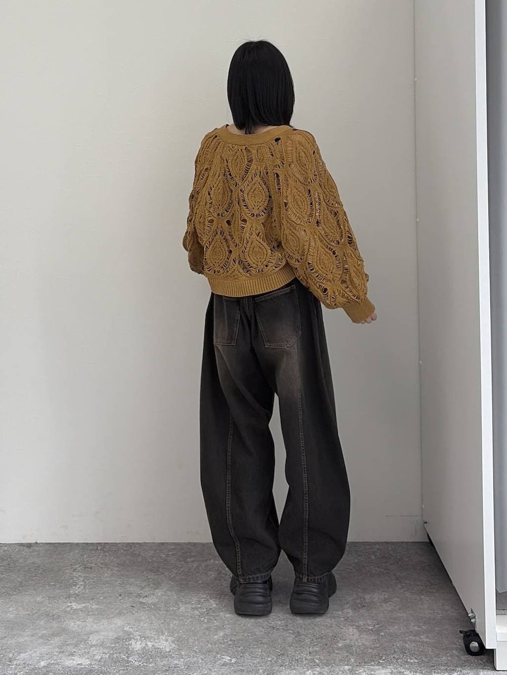 イエロー系のカーディガン/ボレロ、ブラック系のデニムパンツ、シルバー系のネックレスを着用したレディースの冬コーディネートの3枚目の写真