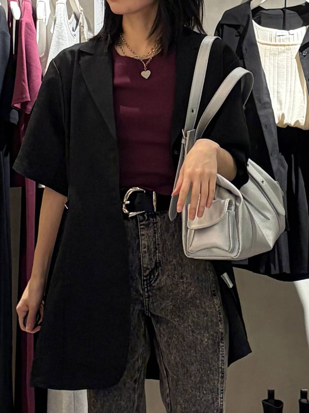 ブラック系のデニムパンツ、ブラック系のテーラードジャケット、シルバー系のハンドバッグを着用したレディースの春コーディネートの4枚目の写真