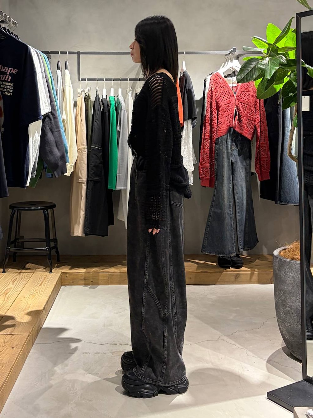 ブラック系のブーツ、ブラック系のデニムパンツ、ブラック系のニット/セーターを着用したレディースの春コーディネートの2枚目の写真