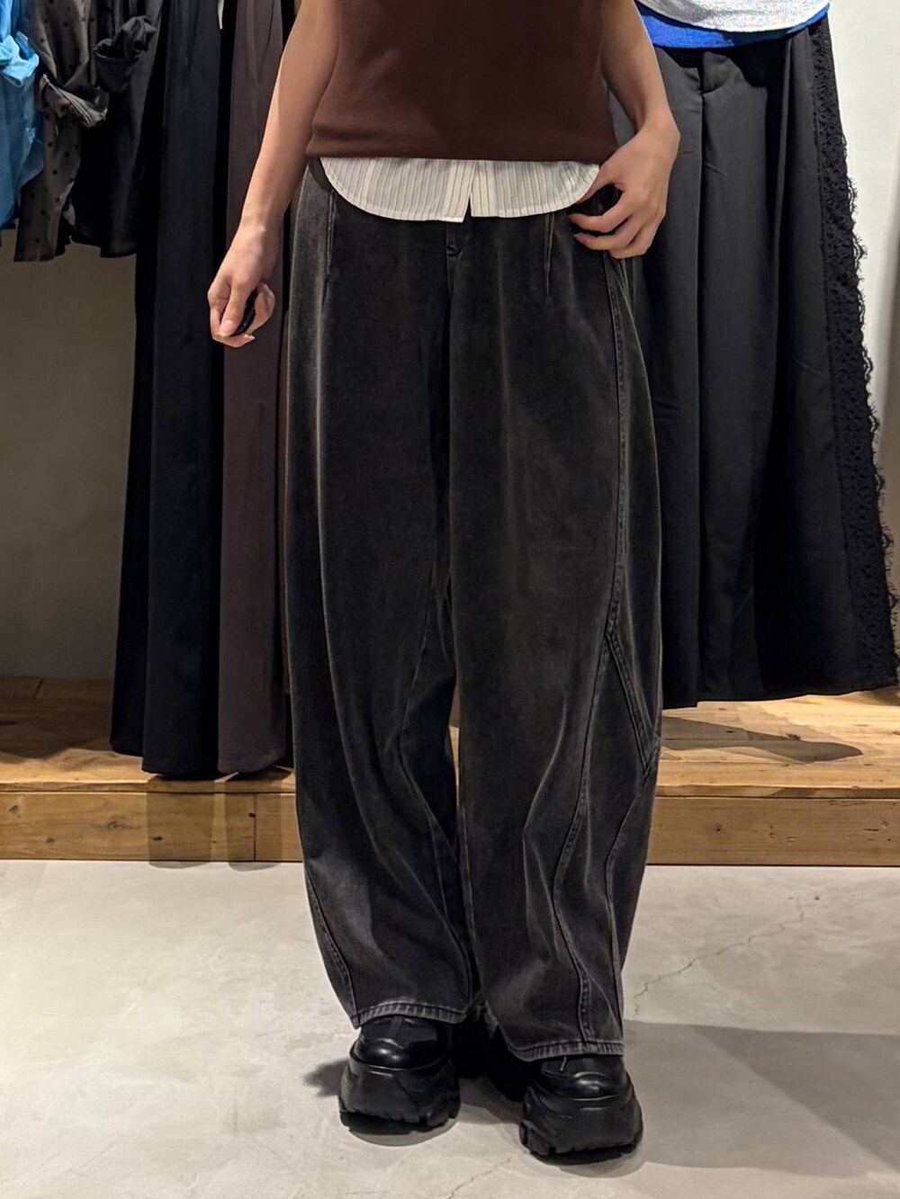 ブラック系のスニーカー、ブラック系のデニムパンツ、ブラウン系のタンクトップを着用したレディースの夏コーディネートの5枚目の写真
