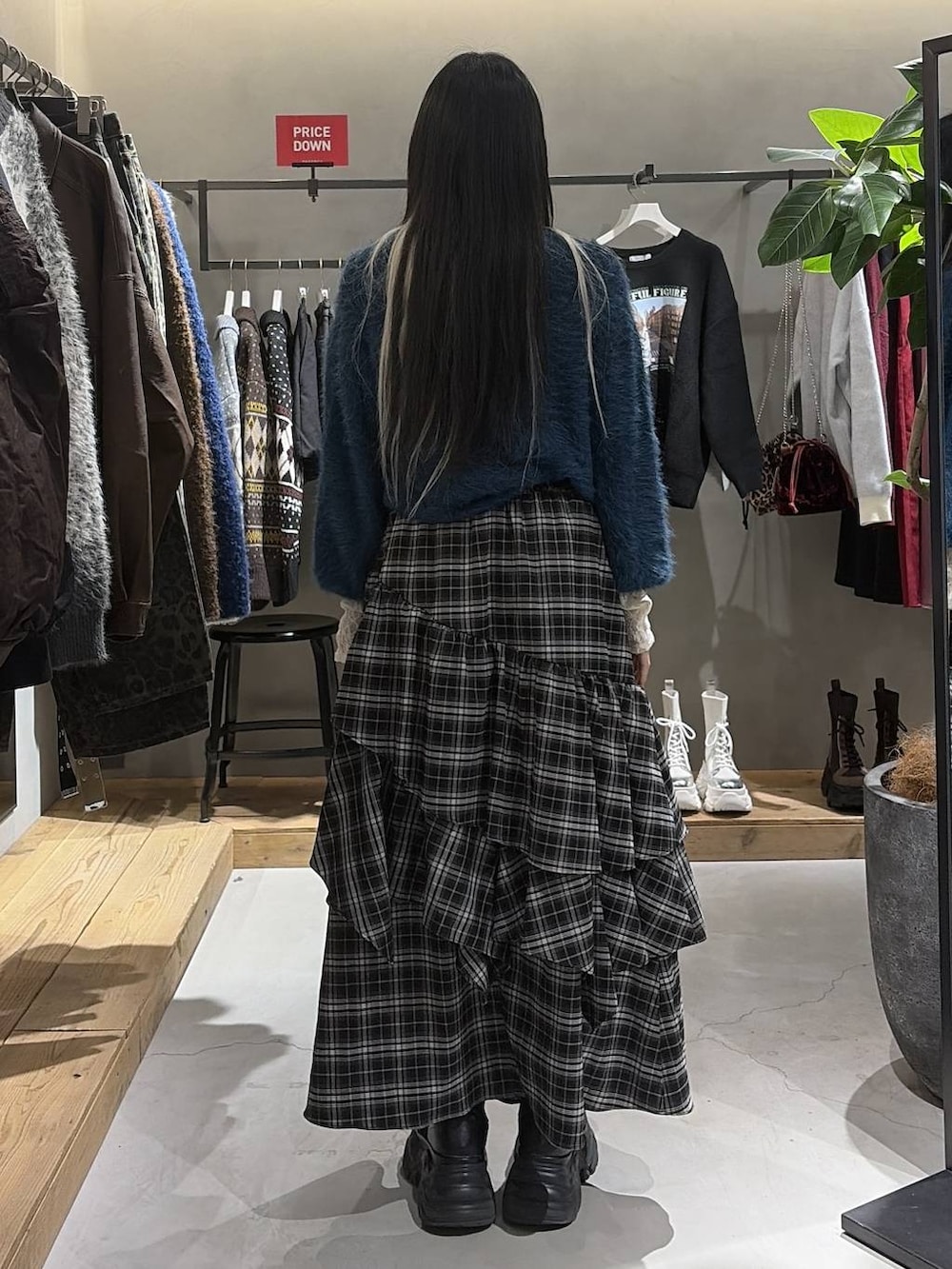 ブラック系のブーツ、ホワイト系のTシャツ/カットソー、ホワイト系のスカートを着用したレディースの冬コーディネートの3枚目の写真