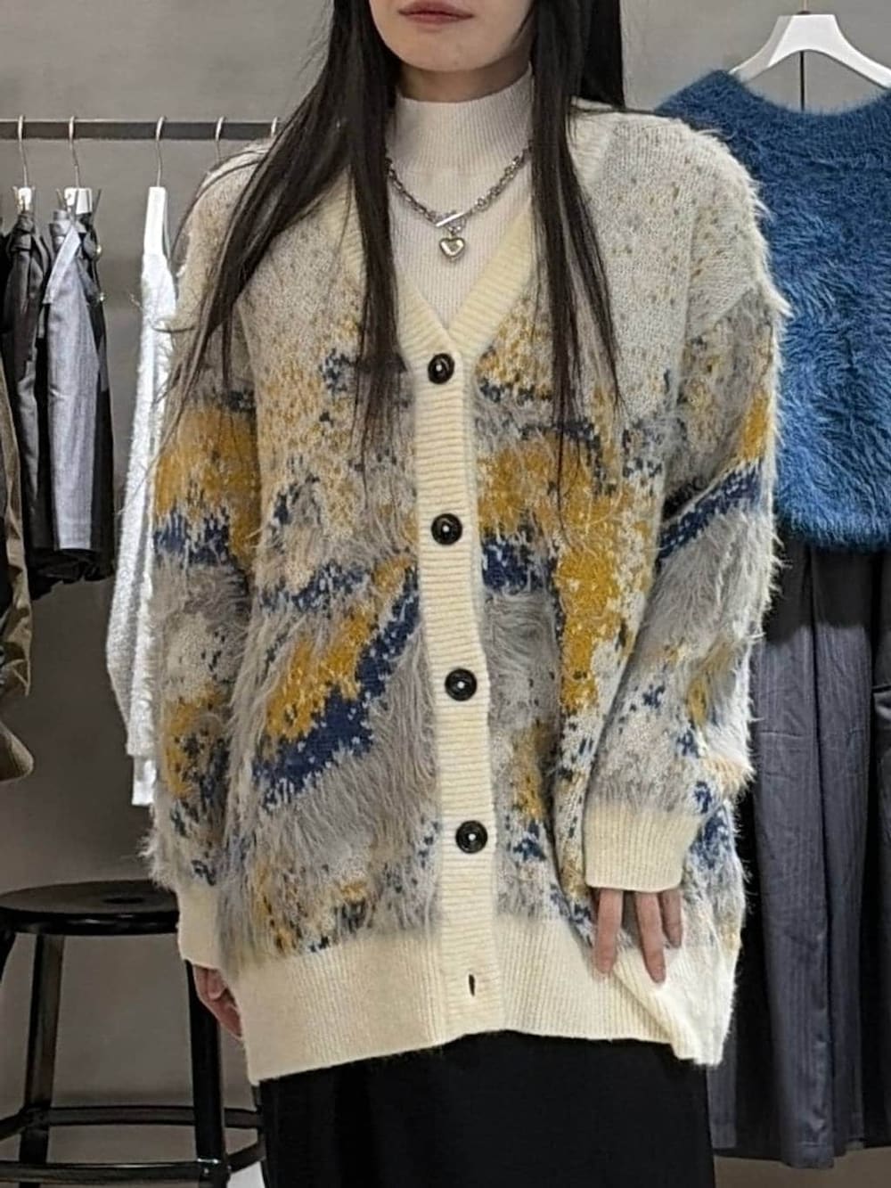 ホワイト系のカーディガン/ボレロ、ホワイト系のニット/セーター、ブラック系のスカートを着用したレディースの冬コーディネートの4枚目の写真