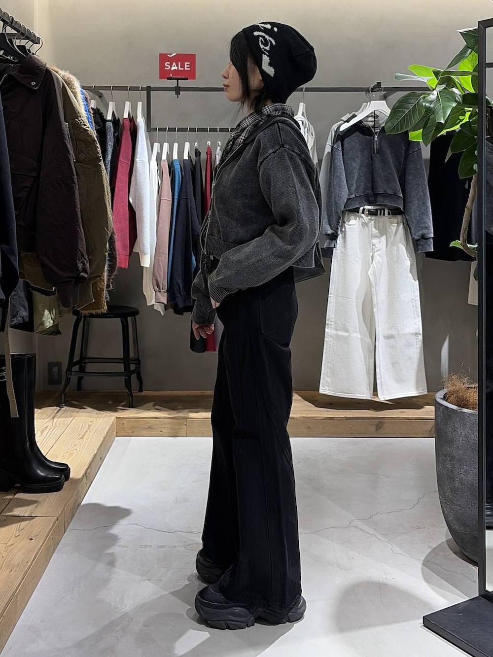 ブラック系のブーツ、ブラック系のボストンバッグ、ブラック系のデニムパンツを着用したレディースの冬コーディネートの2枚目の写真