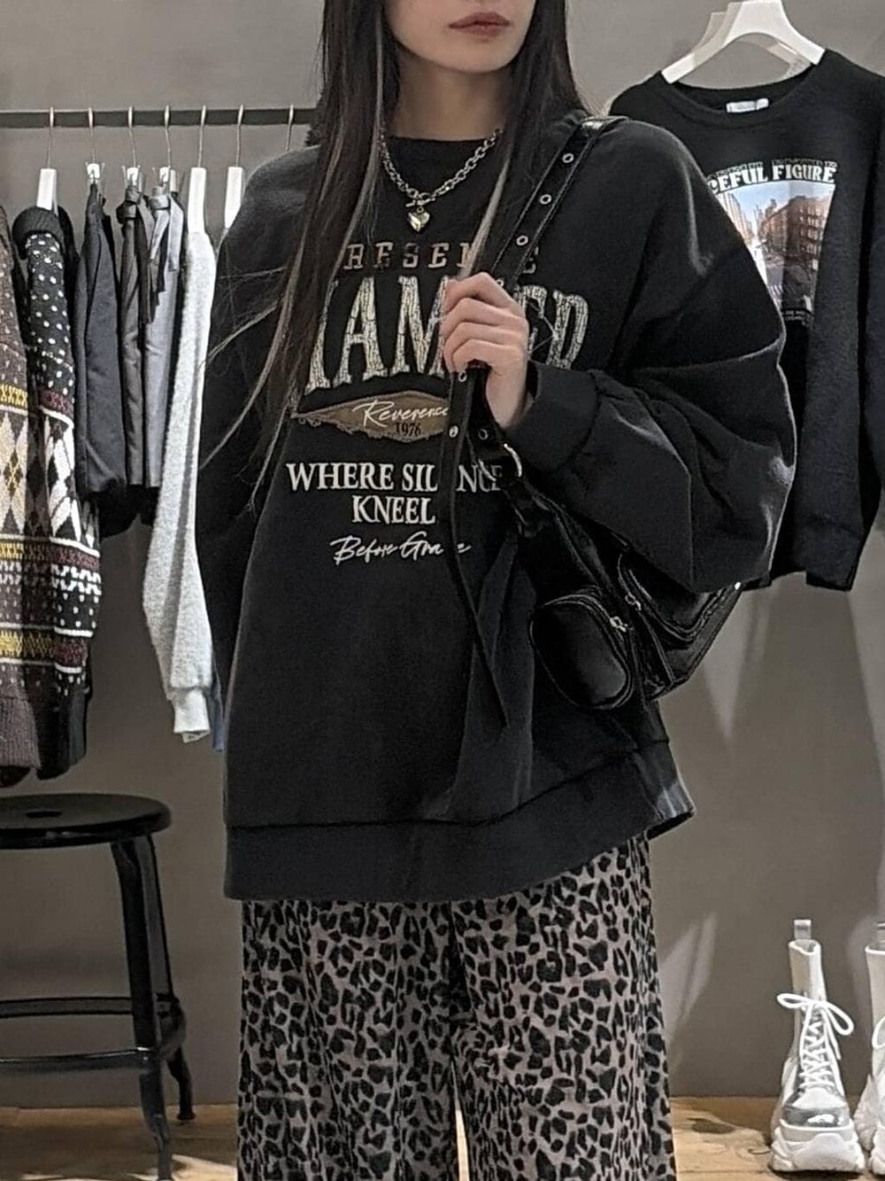 ブラック系のブーツ、グレー系のスウェット、ブラック系のショルダーバッグを着用したレディースの冬コーディネートの4枚目の写真