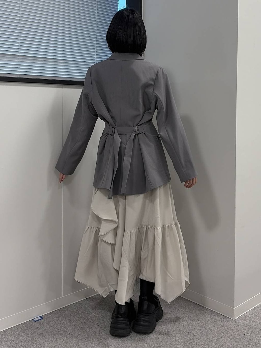 ブラック系のブーツ、ブラック系のニット/セーター、グレー系のテーラードジャケットを着用したレディースの冬コーディネートの3枚目の写真