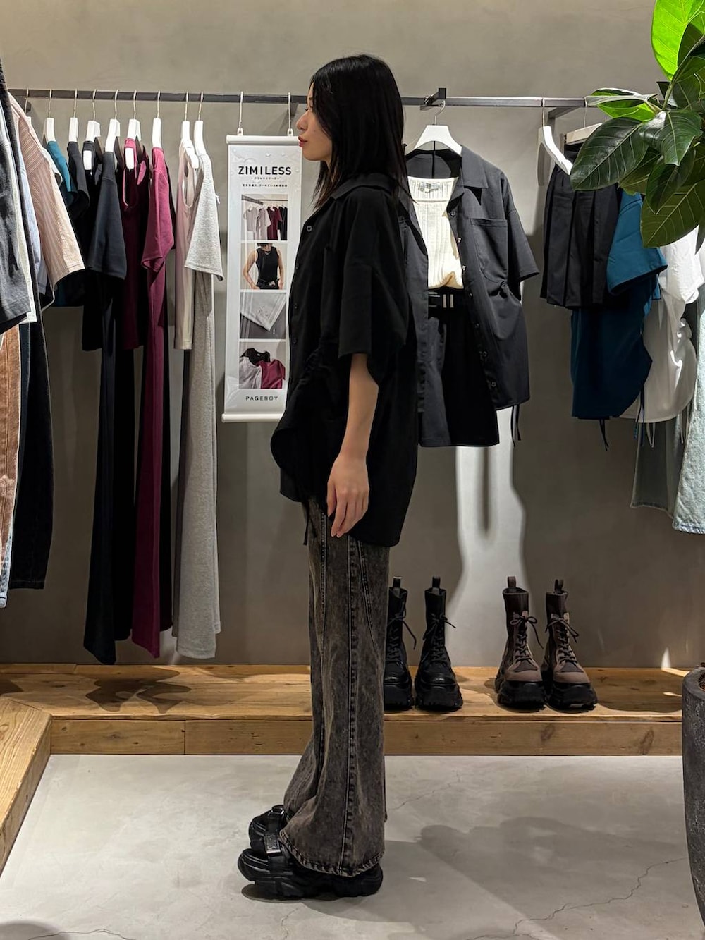 ブラック系のデニムパンツ、ブラック系のサンダル、ブラック系のシャツ/ブラウスを着用したレディースの春コーディネートの2枚目の写真