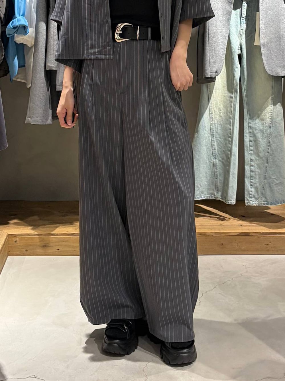 ブラック系のサンダル、ブラック系のTシャツ/カットソー、グレー系のスラックスを着用したレディースの夏コーディネートの5枚目の写真