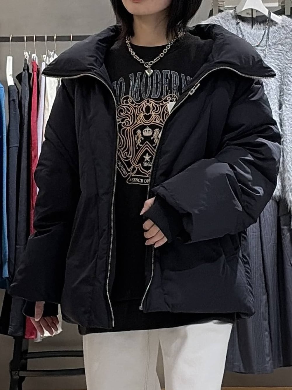 ブラック系のブーツ、ブラック系のブルゾン、ホワイト系のスラックスを着用したレディースの冬コーディネートの4枚目の写真