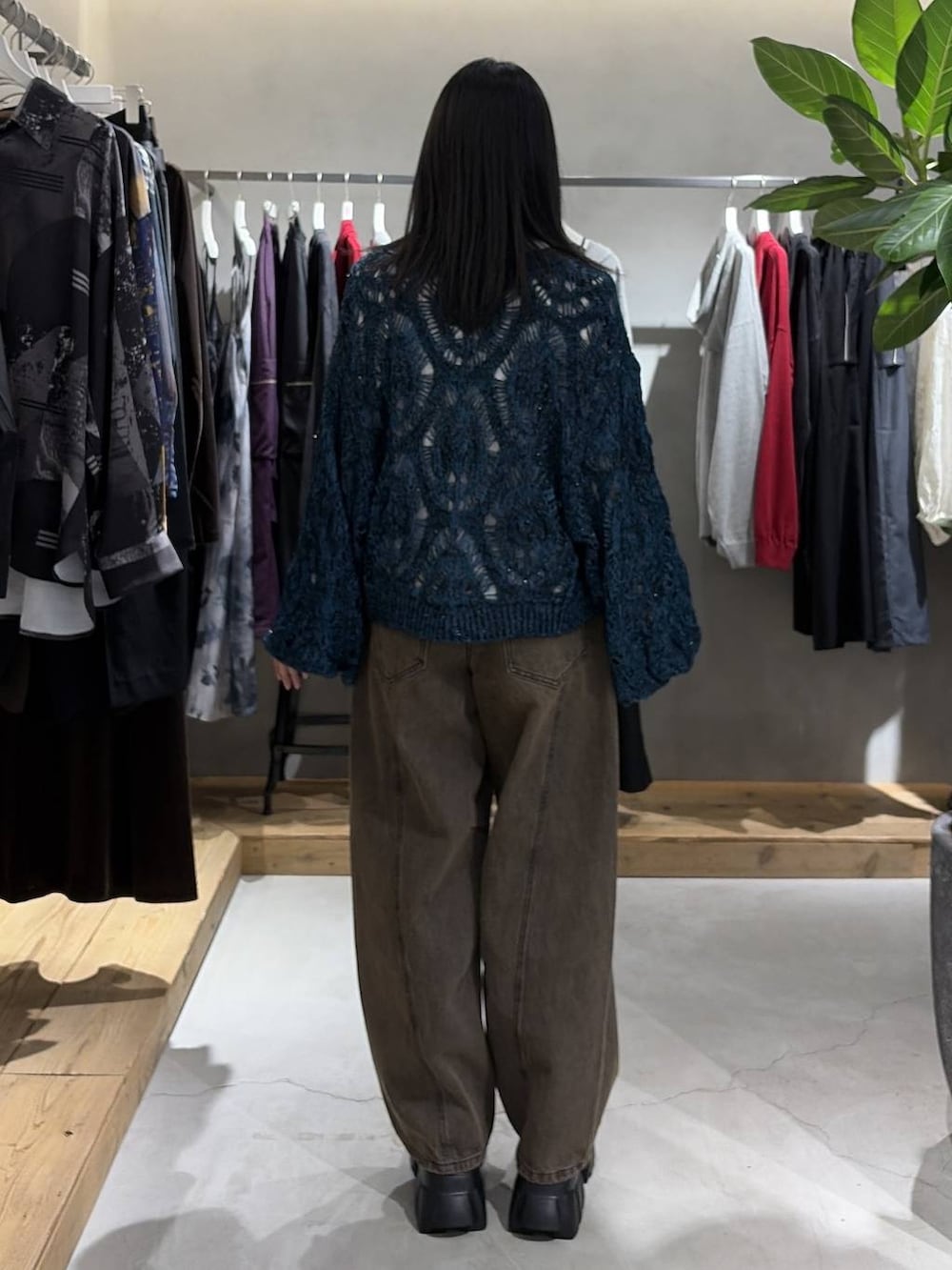 ブラック系のブーツ、ブラウン系のデニムパンツ、ブルー系のカーディガン/ボレロを着用したレディースの秋コーディネートの3枚目の写真