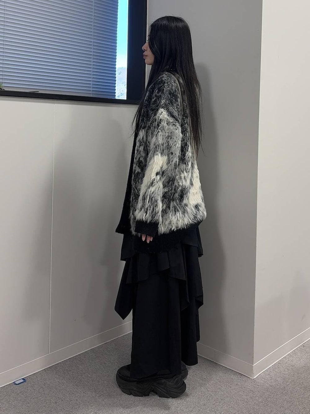 ブラック系のブーツ、ブラック系のスカート、ブラック系のカーディガン/ボレロを着用したレディースの冬コーディネートの2枚目の写真