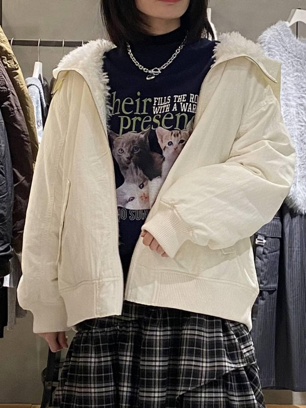 ブラック系のブーツ、ホワイト系のブルゾン、ホワイト系のスカートを着用したレディースの冬コーディネートの4枚目の写真