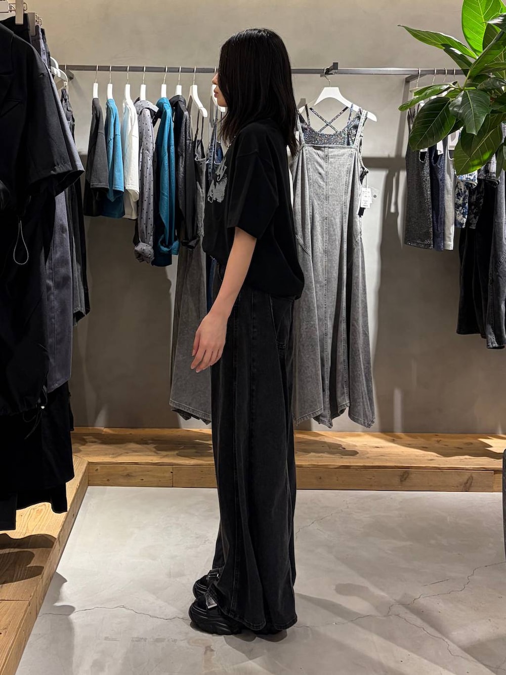 ブラック系のデニムパンツ、ブラック系のTシャツ/カットソー、ブラック系のサンダルを着用したレディースの夏コーディネートの2枚目の写真
