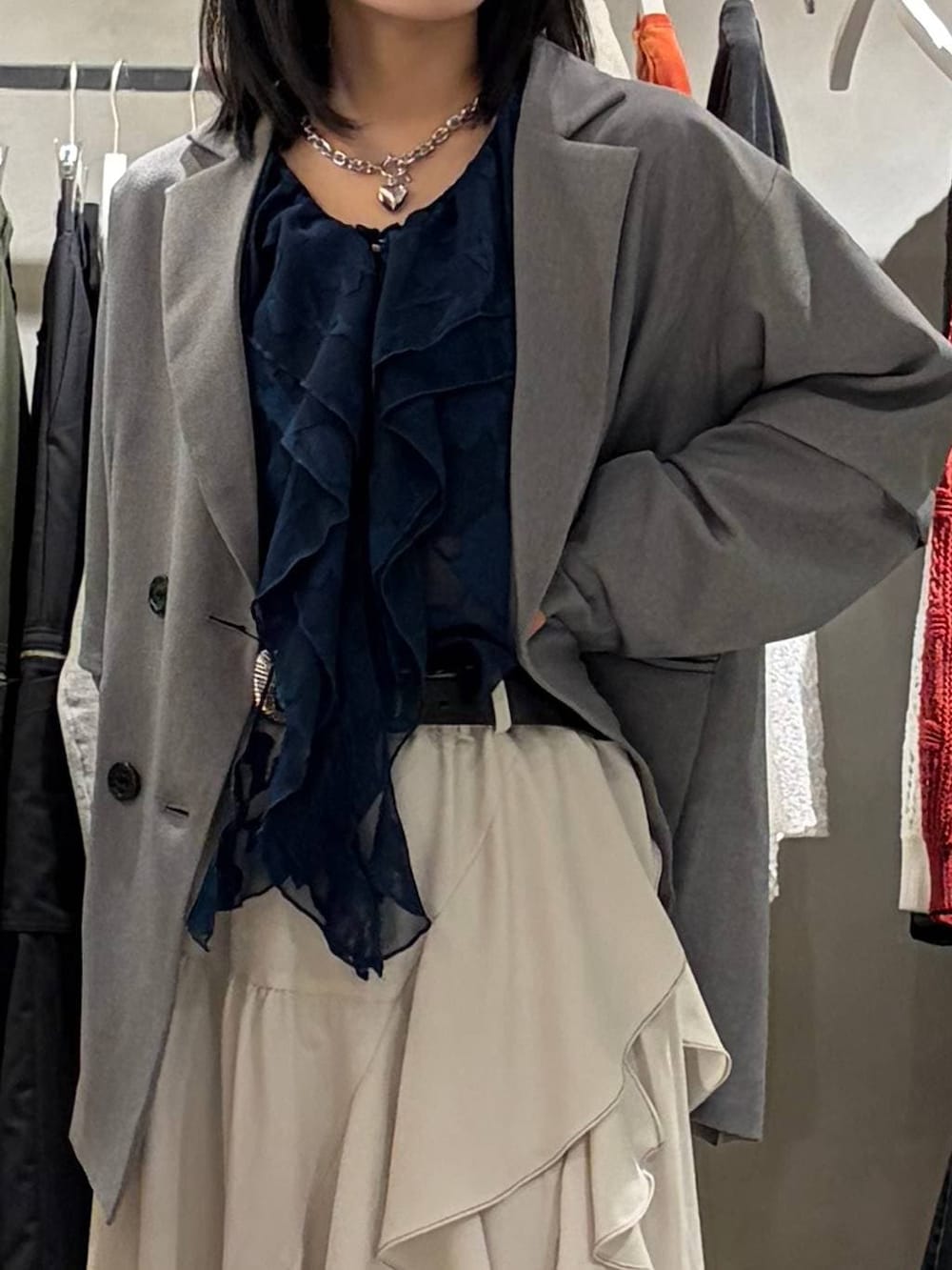 ブラック系のブーツ、ベージュ系のスカート、グレー系のテーラードジャケットを着用したレディースの春コーディネートの4枚目の写真