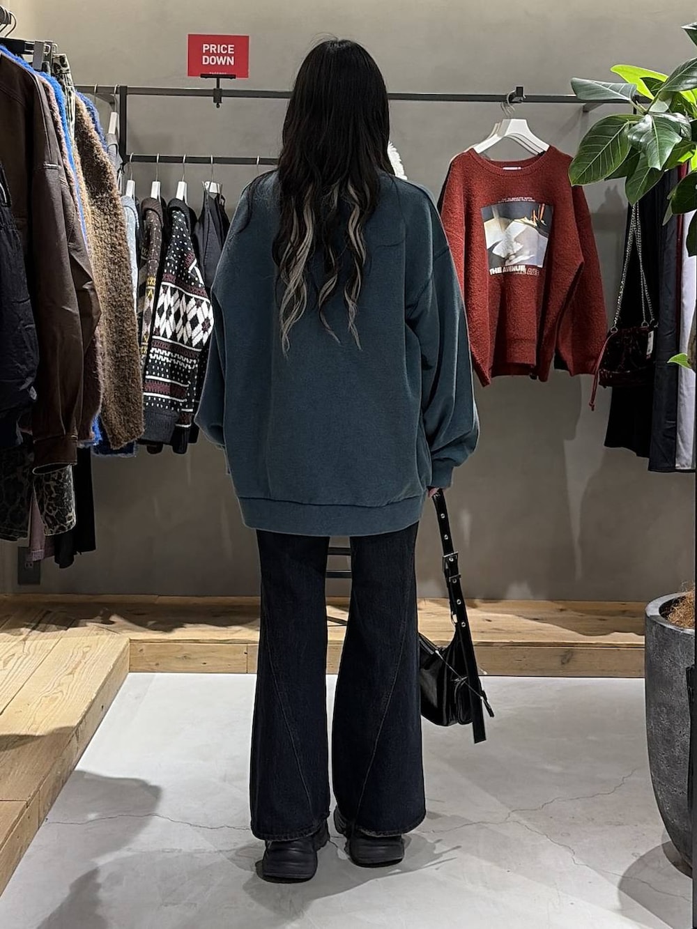 ブラック系のブーツ、ブルー系のデニムパンツ、グリーン系のスウェットを着用したレディースの冬コーディネートの3枚目の写真