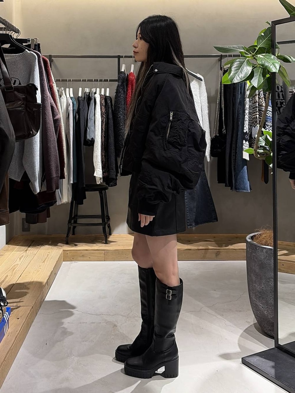 ブラック系のブーツ、ブラック系のスカート、ブラック系のブルゾンを着用したレディースの冬コーディネートの2枚目の写真