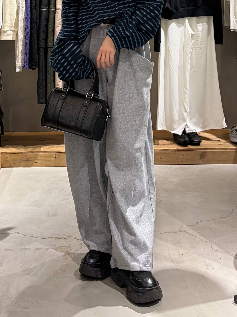 ブラック系のブーツ、ブラック系のボストンバッグ、グレー系のスウェットパンツを着用したレディースの冬コーディネートの5枚目の写真