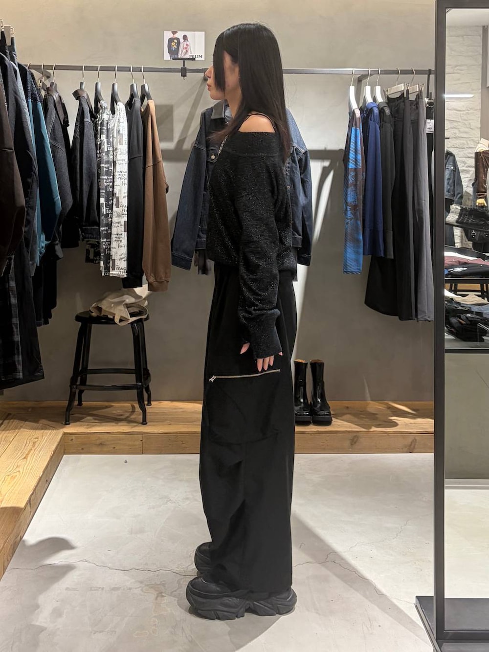 ブラック系のカーゴパンツ、ブラック系のニット/セーター、ブラック系のブーツを着用したレディースの秋コーディネートの2枚目の写真