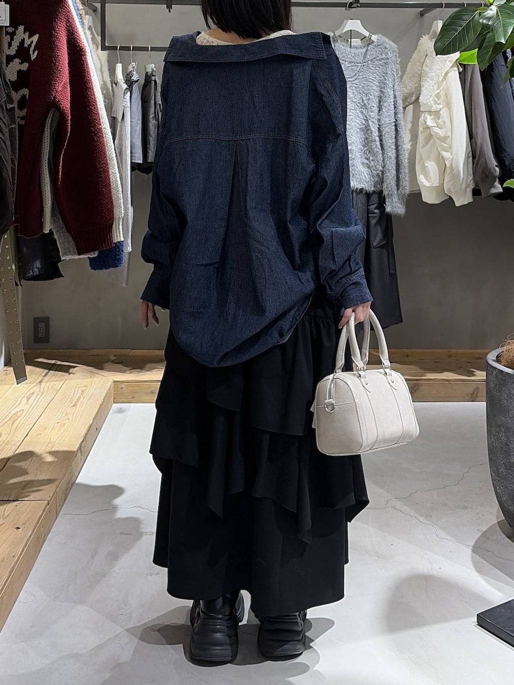 ホワイト系のブルゾン、ホワイト系のTシャツ/カットソー、ブラック系のスカートを着用したレディースの冬コーディネートの7枚目の写真