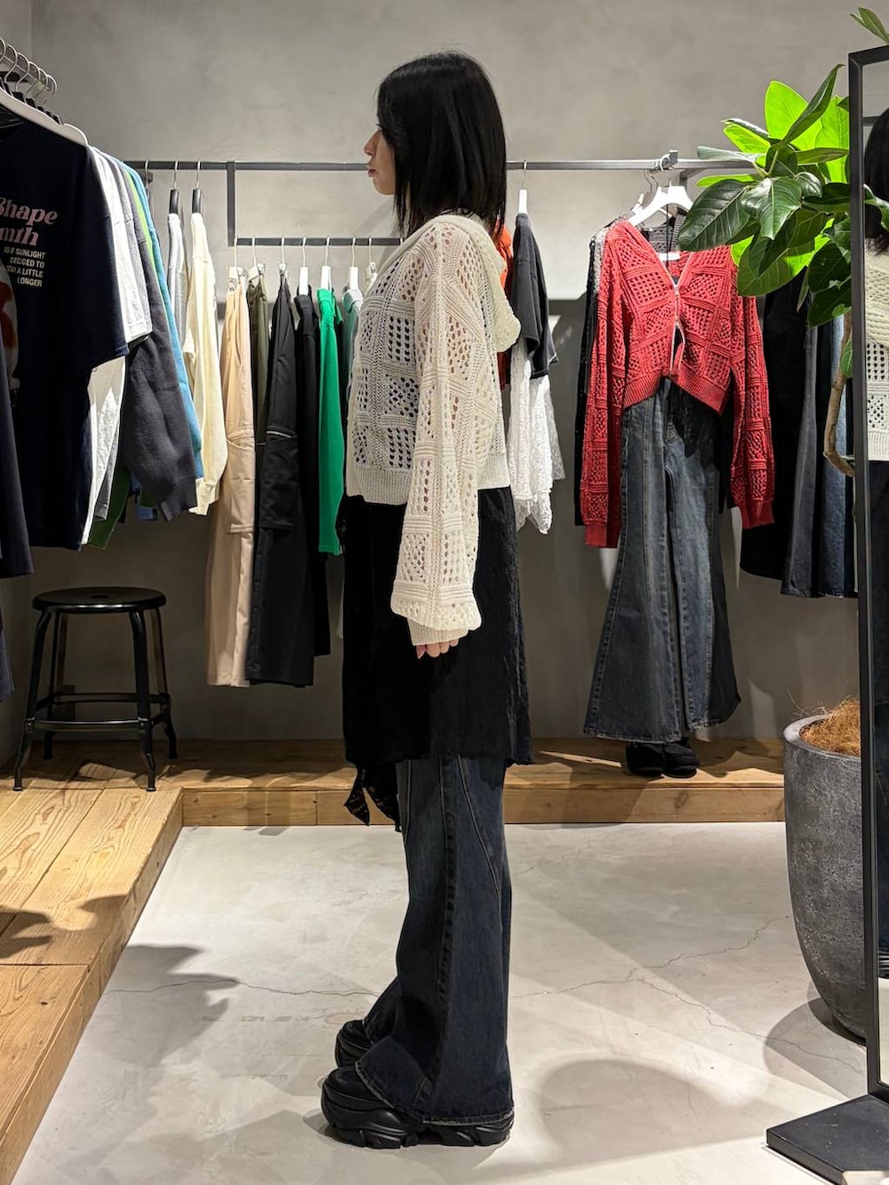 ブラック系のブーツ、ブルー系のデニムパンツ、ホワイト系のパーカーを着用したレディースの春コーディネートの2枚目の写真