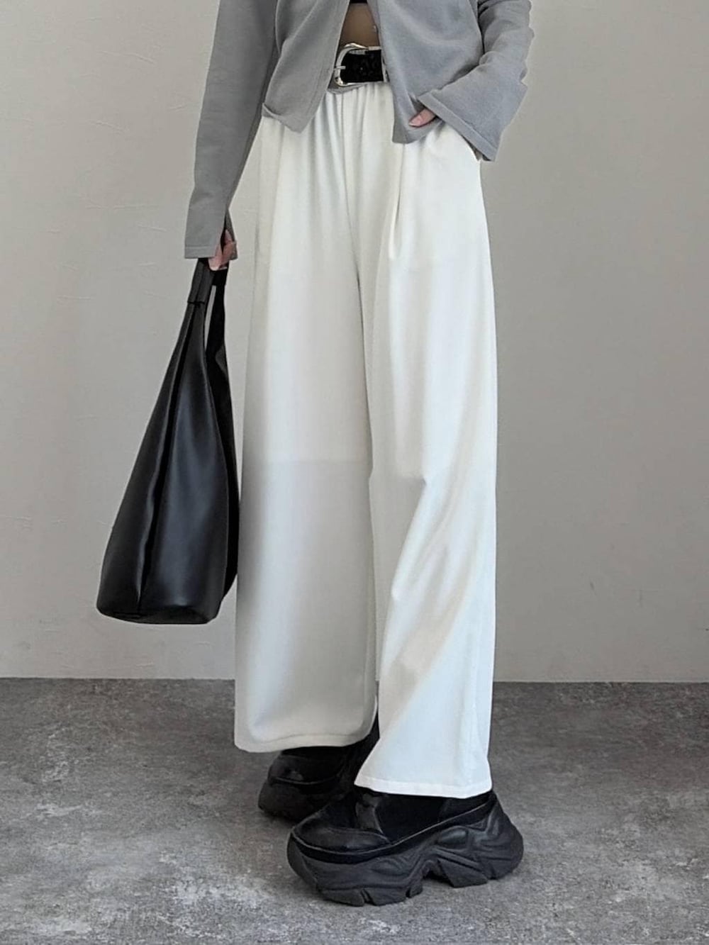 ブラック系のブーツ、ブラック系のトートバッグ、グレー系のカーディガン/ボレロを着用したレディースの冬コーディネートの5枚目の写真