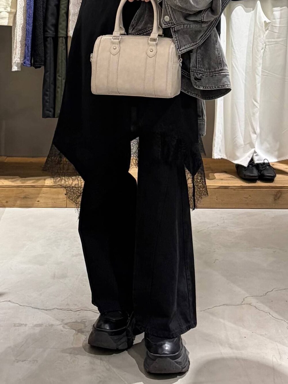 ブラック系のブーツ、ブラック系のデニムパンツ、ホワイト系のボストンバッグを着用したレディースの冬コーディネートの5枚目の写真