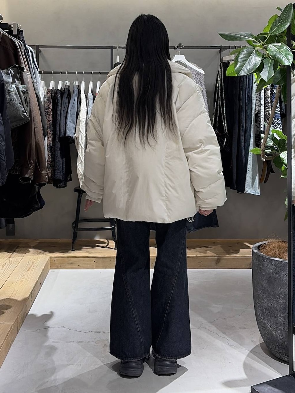 ブラック系のブーツ、ブルー系のデニムパンツ、ホワイト系のブルゾンを着用したレディースの冬コーディネートの3枚目の写真