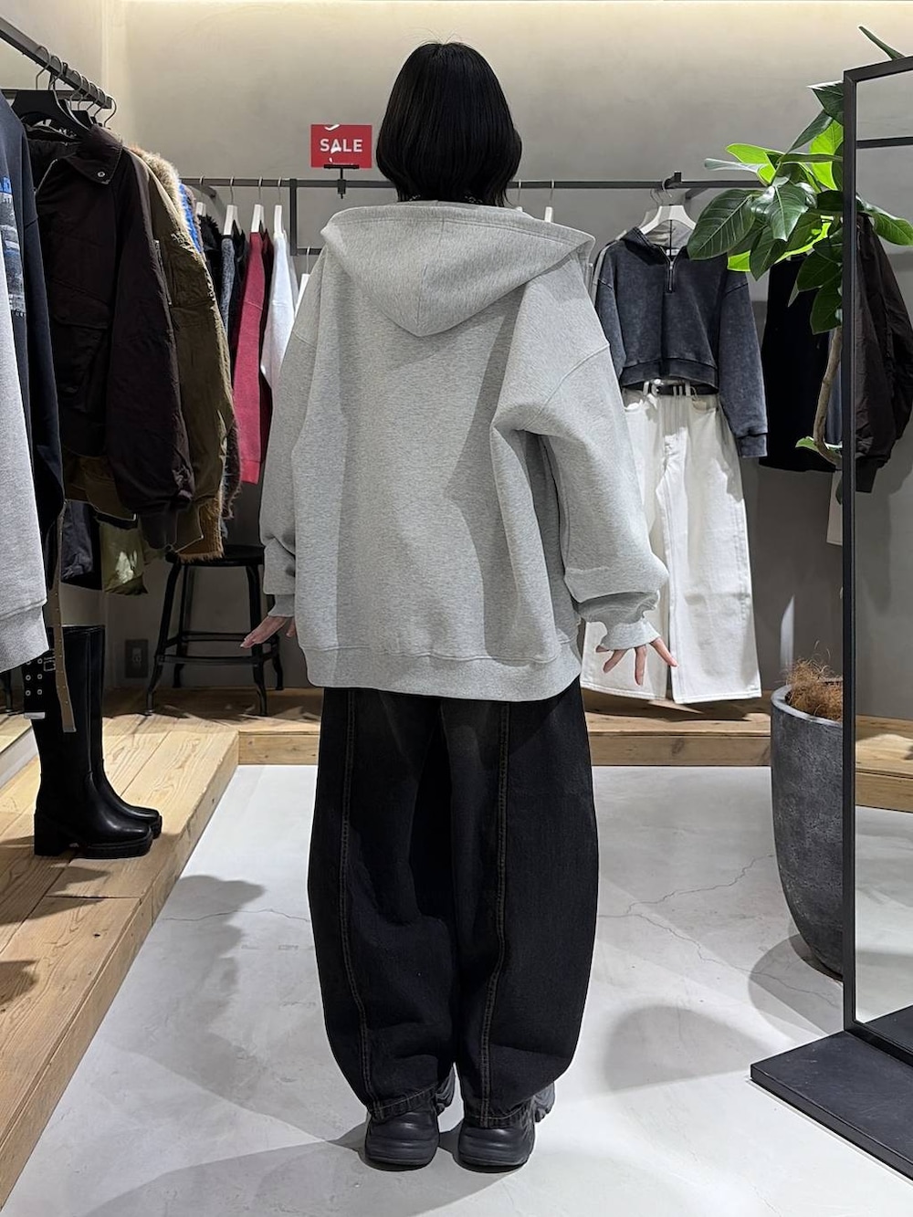 ブラック系のブーツ、グレー系のパーカー、ブラック系のデニムパンツを着用したレディースの冬コーディネートの3枚目の写真