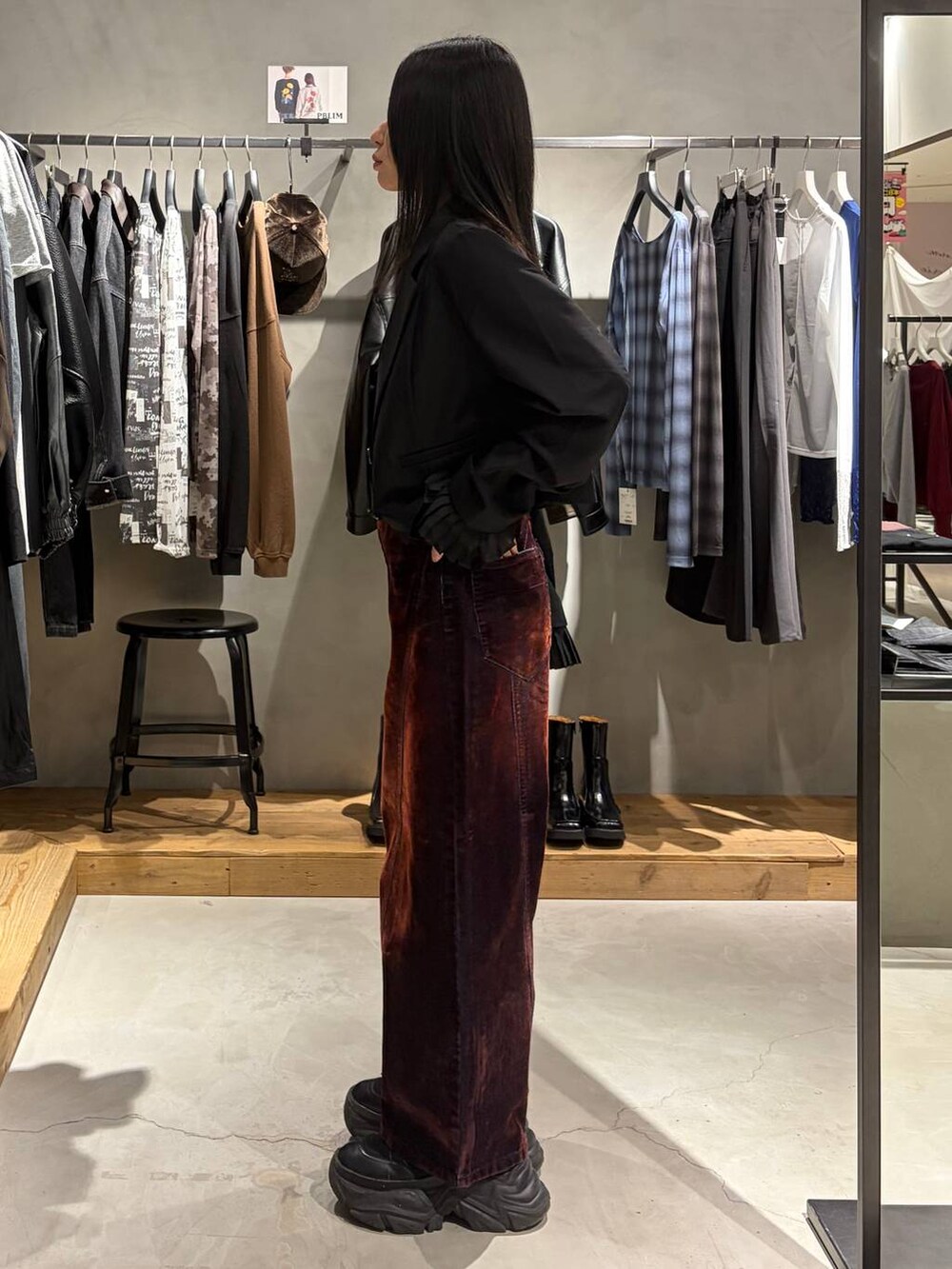ブラック系のテーラードジャケット、レッド系のデニムパンツ、ブラック系のブーツを着用したレディースの秋コーディネートの2枚目の写真