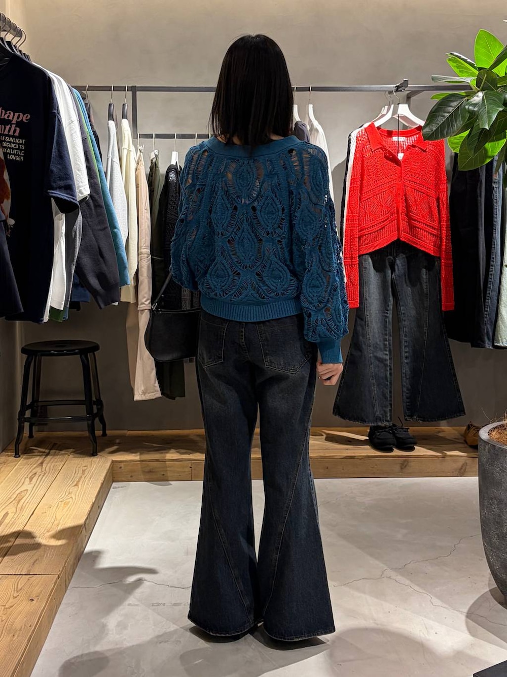 ブルー系のカーディガン/ボレロ、ブルー系のデニムパンツ、ブラック系のハンドバッグを着用したレディースの春コーディネートの3枚目の写真