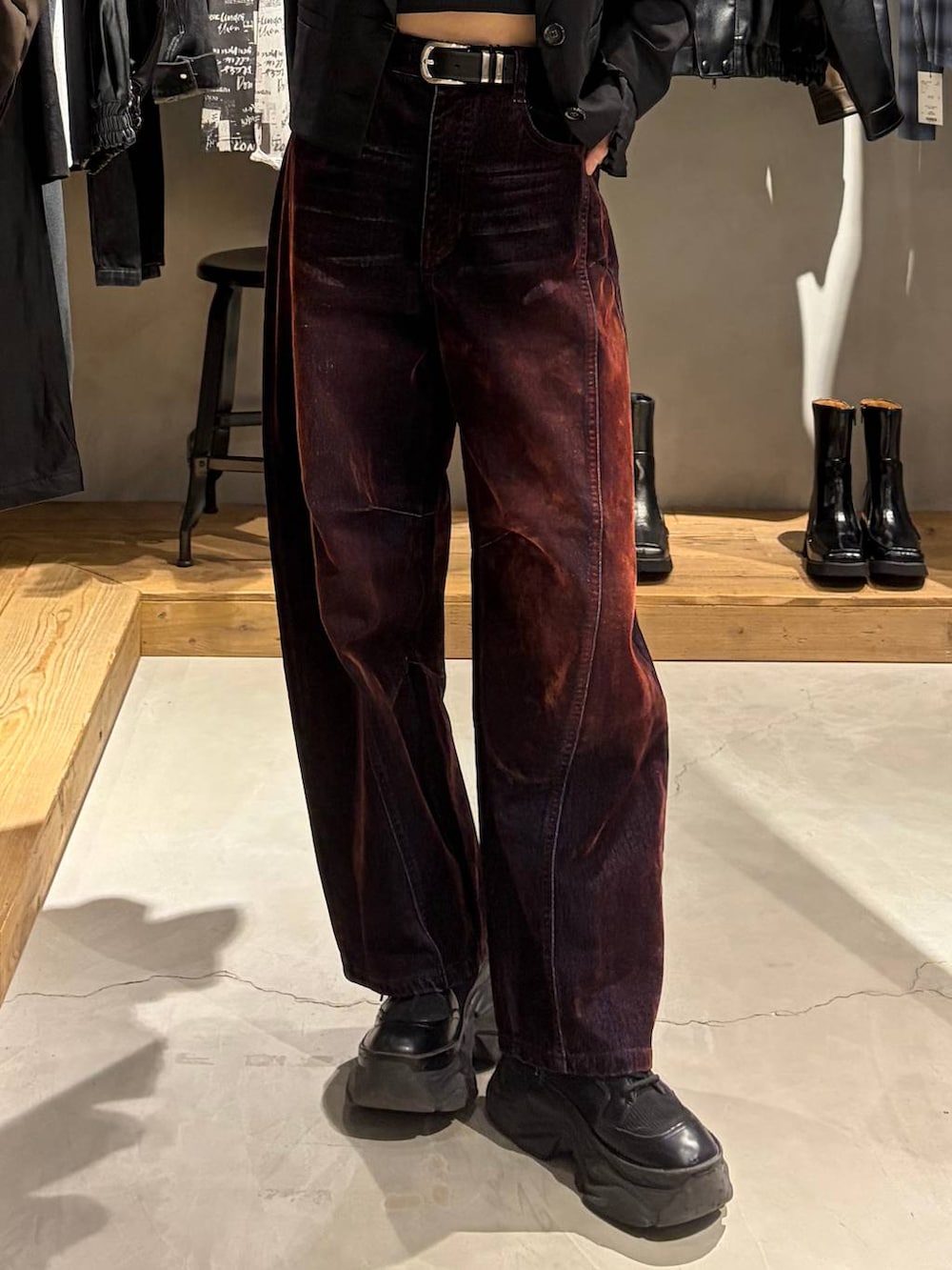 ブラック系のテーラードジャケット、レッド系のデニムパンツ、ブラック系のブーツを着用したレディースの秋コーディネートの5枚目の写真
