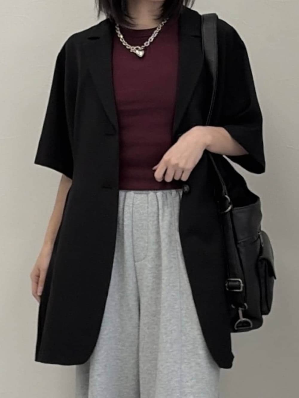 グレー系のスウェットパンツ、ブラック系のショルダーバッグ、ブラック系のテーラードジャケットを着用したレディースの春コーディネートの4枚目の写真